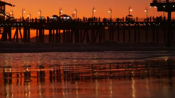 Kalifornischer Sommerstrand, goldener Sonnenuntergang. Lebendiger Himmel über pazifischen Meereswellen. Santa Monica beliebter Ferienort, Los Angeles CA USA. Berühmte Seebrücke gegen stimmungsvollen Abendsonnenuntergang in LA — Stockvideo