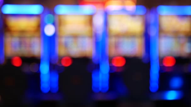 Defocused slot machines glow in casino on fabulous Las Vegas Strip, USA. Blurred gambling jackpot slots in hotel near Fremont street. Illuminated neon fruit machine for risk money playing and betting — Stock Video