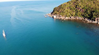 Tropikal kıyıya yakın bir tekne. Tropik volkanik adanın kıyıları yakınlarındaki sakin deniz suyunda seyreden modern yatın insansız hava aracı görüntüsü. Egzotik Cennet Koh Samui, Silver Beach