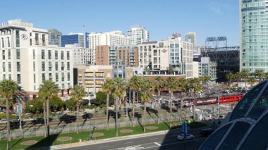 SAN DIEGO, CALIFORNIA USA - 13 Şubat 2020: MTS kırmızı tramvay ve metropol silueti, şehir merkezindeki gökdelenler. Havadan bakıldığında Gaslamp Quarter ve tramvayındaki çeşitli binalar.