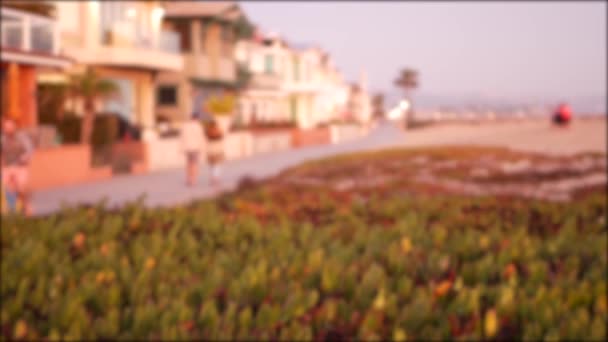 California verão crepúsculo praia estética, pôr do sol rosa sobre casas de fim de semana à beira-mar. Desfocado desfocado pessoas caminhando, passeio marítimo em Newport, pacífico oceano resort perto de Los Angeles CA EUA — Vídeo de Stock