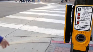 Yaya geçidinde trafik ışığı düğmesi, insanlar itmek ve beklemek zorunda. ABD 'de halkın güvenliği için trafik kuralları ve yönetmelikleri. Zebra caddesi San Diego, Kaliforniya 'da yol ayrımında kesişiyor.