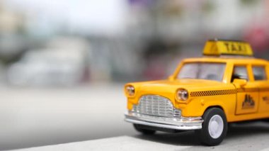 Sarı, boş, mini taksi, Harmon köşesi, Las Vegas, ABD. Odaklanamayan arka planda küçük bir eski araba modeli. Yumuşak odak noktasında ulaşım sembolü olarak küçük ikonik otomobil oyuncağı. Bulanık alışveriş merkezi