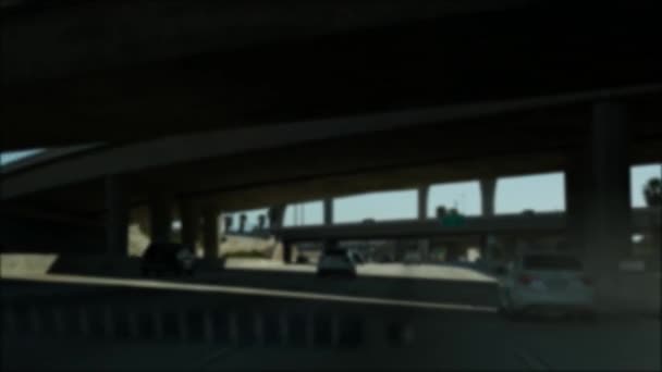 Rijden op de snelweg in Los Angeles, Californië, USA. Gedempt zicht van auto door glazen voorruit op drukke snelweg. Wazige voorstad meerbaans oprit. Camera binnen auto in Los Angeles — Stockvideo