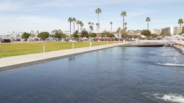 Fontänen i strandnära stadspark nära San Diego County medborgarcenter i centrum, Kaliforniens statliga myndighet, USA. Stilla Havets hamn, embarkadero i Gaslamp Quarter. Palmer och gräs nära piren — Stockvideo