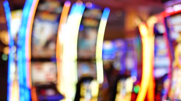 Расслабленные игровые автоматы светятся в казино на сказочном Лас-Вегас Стрип, США. Размытые игровые автоматы в отеле рядом с Фримонт-стрит. Иллюминированный неоновые фрукты машина для игры на деньги риска и ставок — стоковое видео
