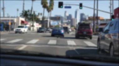 Los Angeles, Kaliforniya 'nın şehir merkezindeki caddelerde araba sürüyorum. Garaj yolundaki arabanın ön camından odaklı olmayan görüntü. Hollywood 'da araçları olan bulanık bir yol. Kamera otomobilin içinde, LA şehri estetiği..