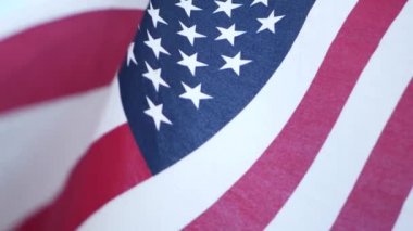Rüzgarda dalgalanan Amerikan bayrağının yumuşak odak noktası. Yıldızlar ve Şeritler demokrasisi, vatanseverlik, özgürlük ve Bağımsızlık Günü sembolü. Yıldızlarla bezeli bayrak, ulusal gurur ve özgürlük ikonu