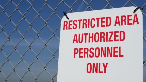 Zone réglementée, le personnel autorisé ne signe qu'aux États-Unis. Lettres rouges, pas d'avertissement sur la clôture en métal, symbole de la frontière américaine. Aucun avis d'intrusion signifie que les contrevenants seront poursuivis par la loi américaine — Video