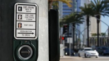 Yaya geçidinde trafik ışığı düğmesi, insanlar itmek ve beklemek zorunda. ABD 'de halkın güvenliği için trafik kuralları ve yönetmelikleri. Zebra caddesi San Diego, Kaliforniya 'da yol ayrımında kesişiyor.