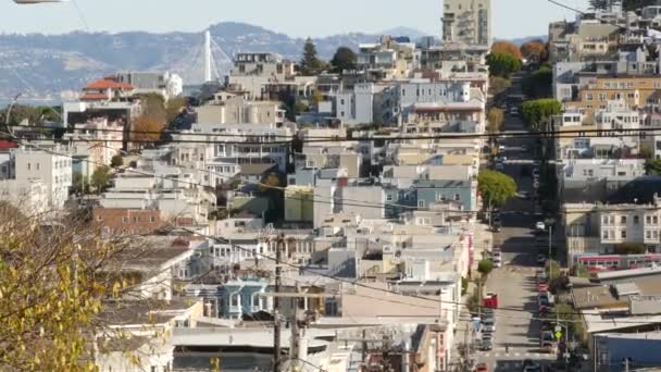 Iconic hilly street and crossroads in San Francisco, Northern California, USA. Route de descente raide et passerelle piétonne. Immobilier centre-ville, maisons victoriennes et autres bâtiments résidentiels — Video