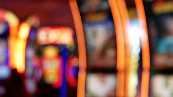 Defocused slot machines glow in casino on fabulous Las Vegas Strip, USA. Blurred gambling jackpot slots in hotel near Fremont street. Illuminated neon fruit machine for risk money playing and betting.