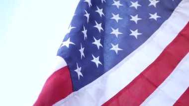 Rüzgarda dalgalanan Amerikan bayrağının yumuşak odak noktası. Yıldızlar ve Şeritler demokrasisi, vatanseverlik, özgürlük ve Bağımsızlık Günü sembolü. Yıldızlarla bezeli bayrak, ulusal gurur ve özgürlük ikonu