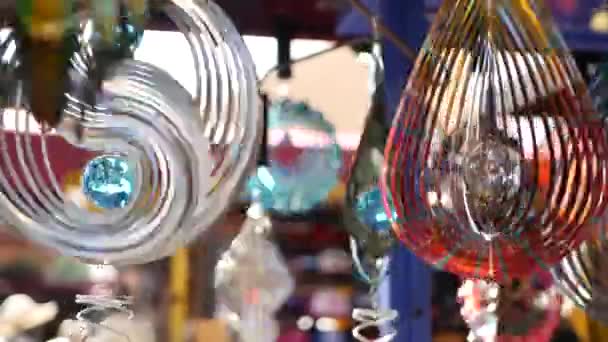 Colorful geometric metallic wind chime spinner, garden hypnotic surreal decoration, California USA. 3D kinetic rotating iridescent multi colored air spiral. Shimmering mesmerising optical illusion — Stock Video