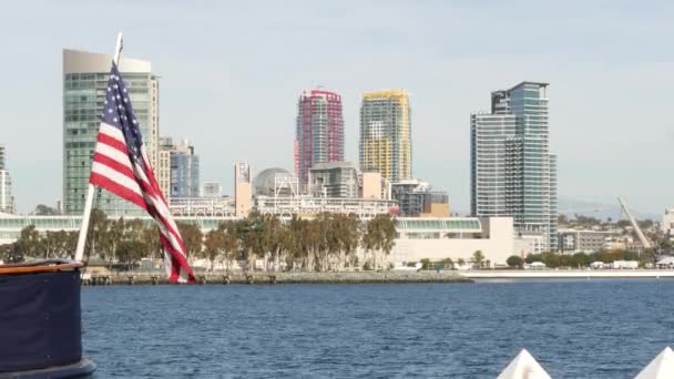 Metropolis urban skyline, highrise skyscrapers of city downtown, San Diego Bay, California USA. Waterfront buildings near pacific ocean harbour. Star-Spangled Banner, Old Glory national flag waving — Stock Video
