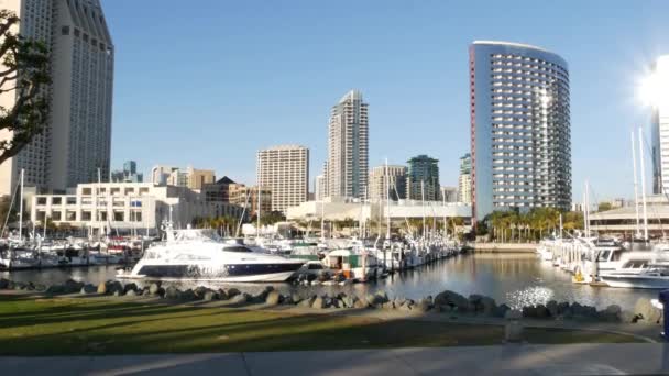 Embarcadero marina park, velké korálové stromy v blízkosti USS Midway a Convention Center, Seaport Village, San Diego, Kalifornie USA. Luxusní jachty a hotely, městské panorama metropole a mrakodrapy Highrise — Stock video