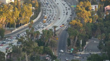 Metropolis, Los Angeles, Kaliforniya 'da yoğun trafik saatleri var. Gün ışığında şehir trafiği sıkışık. Birden fazla şeritteki arabaların hava görüntüsü. Los Angeles 'ta otomobilli otoban.