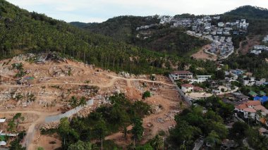 Nesli tükenmekte olan ormanlar ve lüks villalarla kaplı tropikal bir arazi. Binalar ve ormansızlaşma nedeniyle ekosistem bozukluğu olan büyük tropik bölgelere insansız hava aracı görüntüsü. Koh Samui. Hindistan cevizi palmiyesi tarlaları