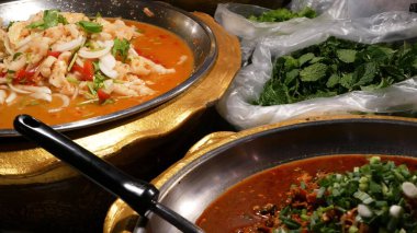 Çeşitli Asya yemekleri olan kaseler. Akşamları sokak lokantasının tezgahına çeşitli geleneksel Tayland yemekleri koyuyorlar. Doğulu gece marketi yemek katı