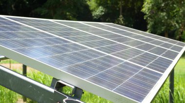 Güneşli bir günde çimlerin üzerindeki güneş panelleri. Çimenlikte ekolojik enerji üreten alternatif enerji santralleri. Çevrenin korunması ve yeşil konsepte geçiş. Modern teknolojiler ve yenilikler
