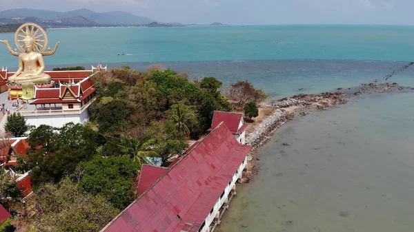 Island with Buddhist temple and many houses. Aerial view of island with Buddhist temple with statue Big Buddha surrounded by traditional houses on stilts in bay of Pacific ocean on Samui, Thailand — Stock Image Island Buddhist Temple Many Houses Aerial View Island Buddhist Temple Royalty Free Stock Photos