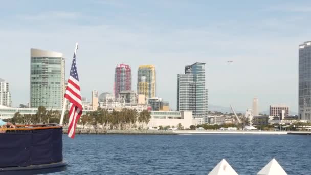 Metropolis stedelijke skyline, hoogbouw wolkenkrabbers van de stad centrum, San Diego Bay, Californië Verenigde Staten. Gebouwen aan het water in de buurt van Stille Oceaan haven. Star-Spangled Banner, Oude Glorie nationale vlag zwaaiend — Stockvideo