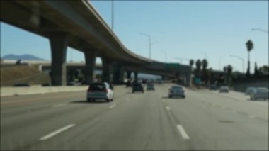 Los Angeles, Kaliforniya 'da şehirlerarası otobanda araba sürüyorum. Yoğun otoyoldaki arabanın cam ön camından odaklanmış görüntüsü. Bulanık banliyö yolu. Kamera Los Angeles 'ta.