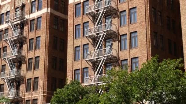 Fire escape ladder outside residential brick building in San Diego city, USA. Typical New York style emergency exit for safe evacuation. Classic retro house exterior as symbol of real estate property — Stock Video