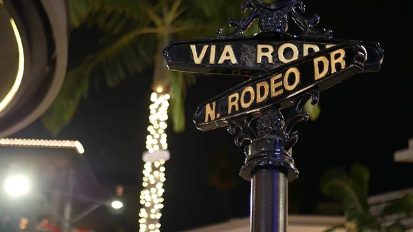 World famous Rodeo Drive symbol, Cross Street Sign, Intersection in Beverly Hills. Touristic Los Angeles, California, USA. Rich wealthy life consumerism, Luxury brands and high-class stores concept