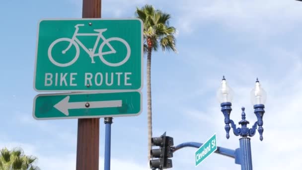 Moto Rota sinal de estrada verde na Califórnia, EUA. Bicicleta faixa singpost. Bikeway em Oceanside estância turística pacífica. Placa de ciclismo e palma. Estilo de vida saudável, recreação e segurança símbolo de ciclismo — Vídeo de Stock