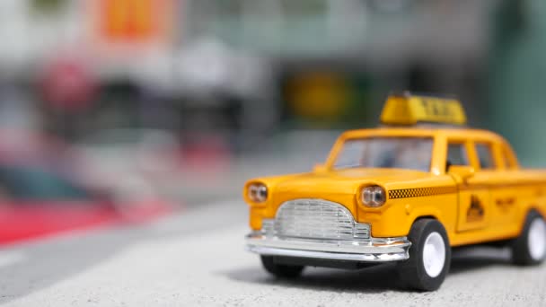 Yellow vacant mini taxi close-up, Harmon corner, Las Vegas, Verenigde Staten. Klein retro auto model op onscherpe achtergrond. Little iconische auto speelgoed als symbool van het vervoer in zachte focus. Wazig winkelcentrum — Stockvideo