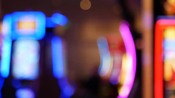 Defocused slot machines glow in casino on fabulous Las Vegas Strip, USA. Blurred gambling jackpot slots in hotel near Fremont street. Illuminated neon fruit machine for risk money playing and betting — Stock Video