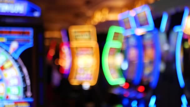 Las máquinas tragamonedas desenfocadas brillan en el casino en la fabulosa Las Vegas Strip, Estados Unidos. Desenfocado juego jackpot ranuras en el hotel cerca de la calle Fremont. Máquina de fruta de neón iluminada para jugar y apostar dinero de riesgo — Vídeo de stock