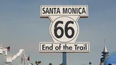 Santa Monica, LOS ANGELES, ABD - 28 OCT 2019: 66. tarihi güzergah, ünlü klasik Kaliforniya gezi sembolü. Pasifik Okyanusu kıyısındaki tatil köyünde. Lunaparkta mavi gökyüzüne karşı ikonik retro yol işareti.
