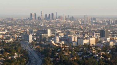 Metropolis 'in yüksek gökdelenleri ve yoğun trafik saatleri, Los Angeles, Kaliforniya ABD. Şehir merkezi silüeti ve trafik sıkışıklığı. Şehir manzarası ve garaj yolundaki arabalar. Los Angeles 'ta çevre yolu