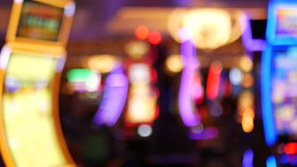 Defocused slot machines glow in casino on fabulous Las Vegas Strip, USA. Blurred gambling jackpot slots in hotel near Fremont street. Illuminated neon fruit machine for risk money playing and betting — Stock Video