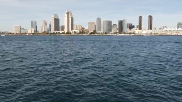 Metropolis stedelijke skyline, hoogbouw wolkenkrabbers van de stad centrum, San Diego Bay, Californië Verenigde Staten. Gebouwen aan het water in de buurt van Stille Oceaan haven. Uitzicht vanaf boot, nautisch openbaar vervoer naar Coronado — Stockvideo