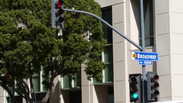 Broadway sokak adı, "odonym" levhası ve ABD 'deki sütunlarda trafik ışığı. Şehir merkezindeki kavşakta. Şehir merkezindeki iş yerinin kesiştiği yerde. Ana cadde başlıklı isim levhası — Stok video