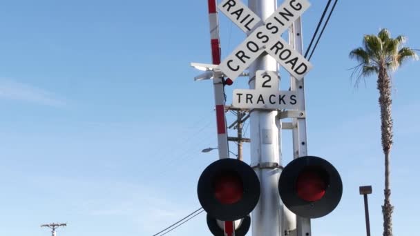 Предупреждающий сигнал пересечения уровня в США. Уведомление о перекрёстке и красный светофор на железнодорожном перекрестке в Калифорнии. Символ безопасности железнодорожного транспорта. Знак предосторожности об опасности и железнодорожных путях — стоковое видео