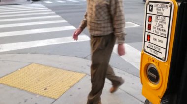 Yaya geçidinde trafik ışığı düğmesi, insanlar itmek ve beklemek zorunda. ABD 'de halkın güvenliği için trafik kuralları ve yönetmelikleri. Zebra caddesi San Diego, Kaliforniya 'da yol ayrımında kesişiyor.