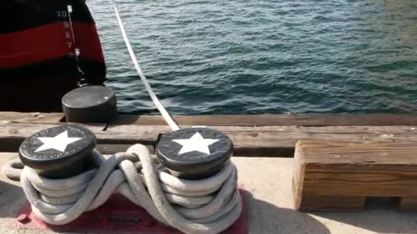 Gefesselter Strickknoten auf metallischem Poller mit Sternen, Seehafen von San Diego, Kalifornien. Das Schiff liegt im Dock. Kabelbinder an Steg befestigt. Symbol der Marine und Flotte, Flagge der USA — Stockvideo