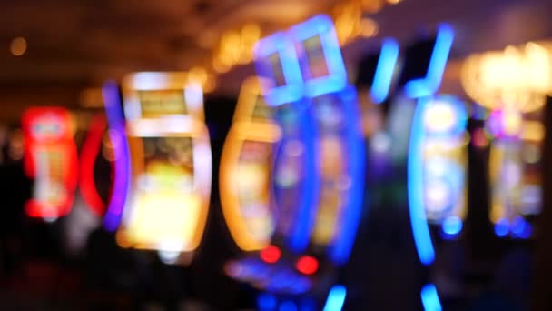 Defocused slot machines glow in casino on fabulous Las Vegas Strip, USA. Blurred gambling jackpot slots in hotel near Fremont street. Illuminated neon fruit machine for risk money playing and betting — Stock Video