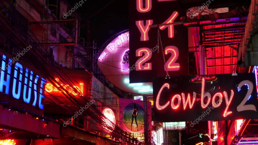 BANGKOK, THAILAND,13 JULY 2019: Vivid neon signs glowing on Soi Cowboy street. Nightlife in erotic Red light district. Illuminated bar and adult go-go show club. Night life tourist entertainment.
