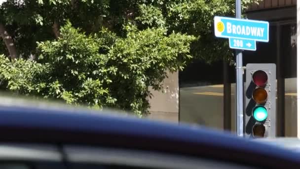 브로드웨이 거리 이름, 미국의 기둥에 붙은 이명 부호, 교통 신호등. 시내의 교차로입니다. 도시 중심의 비즈니스 지구에서 교차로. 주요 거리의 제목이 붙은 명찰 — 비디오