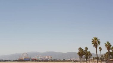 Kaliforniya plaj estetiği, klasik dönme dolap, Santa Monica Pasifik Okyanusu 'ndaki iskeledeki eğlence parkı. Yaz ikonik manzarası, palmiye ağaçları ve gökyüzü, kopya alanı ile Los Angeles 'ın sembolü, CA USA