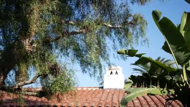 Estilo colonial mexicano suburbano, casa hispânica exterior, verde jardim exuberante, San Diego, Califórnia EUA. Telha de barro cerâmica terracota Mediterrâneo no telhado. Telhado de azulejos espanhol rústico. Dados rurais — Vídeo de Stock