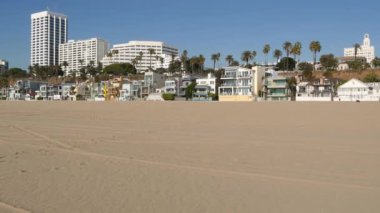 Kaliforniya yazları plaj estetiği, güneşli mavi gökyüzü, kum ve deniz kenarındaki birçok farklı hafta sonu evi. Deniz kenarındaki binalar, Santa Monica Pasifik Okyanusu kıyısındaki emlak merkezi, Los Angeles CA USA