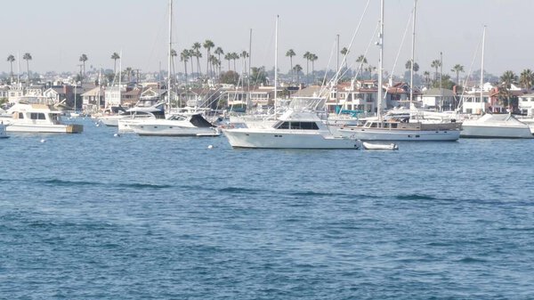 Newport beach harbor, weekend marina resort with yachts and sailboats, Pacific Coast, California, USA. Waterfront luxury suburb real estate in Orange County. Expensive beachfront holiday destination.