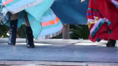 Renkli geleneksel elbiseli Latin kadınlar dans ediyorlar Jarabe Tapatio, Meksika halk şapkası dansı. Çok renkli etnik etek giymiş İspanyol kadın balesinin sokak performansı. Kostümlü kızlar