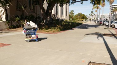 SAN DIEGO, CALIFORNIA USA - 30 HAZİRAN 2020: Yoldaki evsiz sokak insanları, yol kenarındaki kamyon. Los Angeles yakınlarındaki şehir merkezinde dilencilik sorunu. İşsiz dilenciler kaldırımda yük arabası.